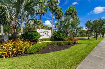 A sign that says "Pleasure Cove" is in front of some trees.